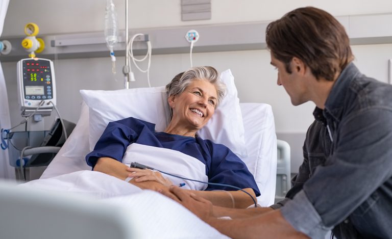 Summit-Financial-of-South-Carolina-senior-woman-smiling-in-hospital-bed Medical Bills